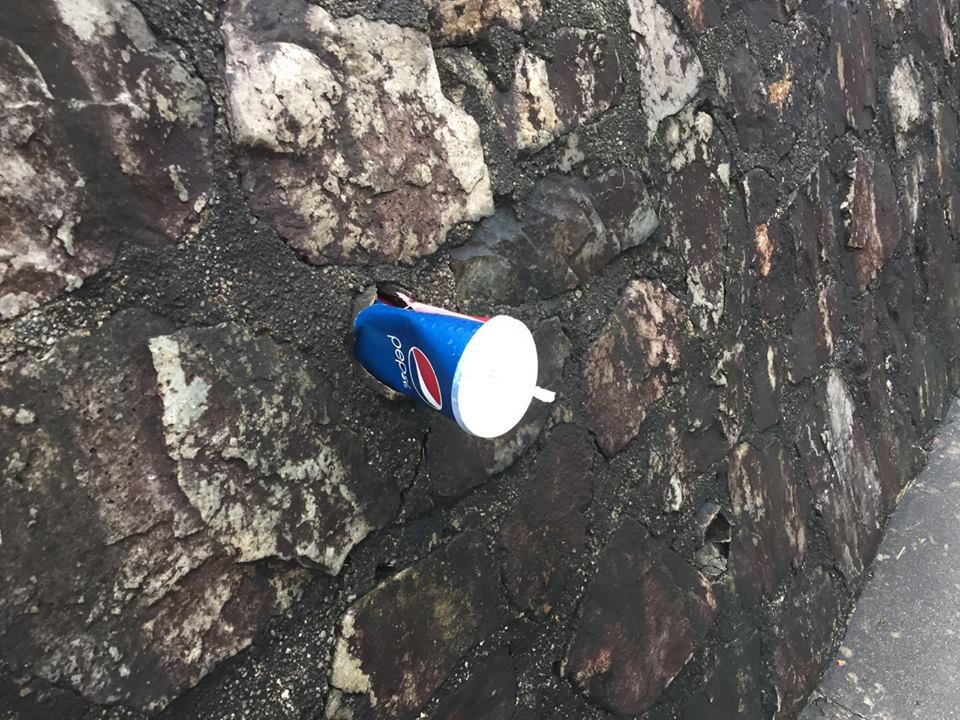 虽然附近有垃圾桶，但有人选择在走道旁的墙壁塞汽水杯。（摄影/宋慧纯）