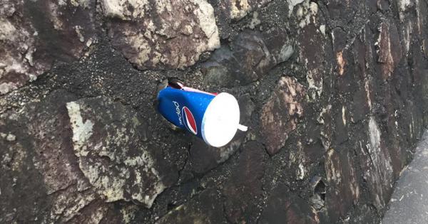 虽然附近有垃圾桶，但有人选择在走道旁的墙壁塞汽水杯。（摄影/宋慧纯）