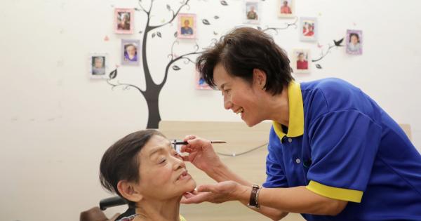 侯玉华细心的为乐龄人士上妆，把她们打扮得漂漂亮亮的。（林国明 摄）