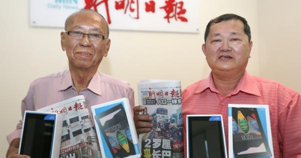 读者邓健祥（左）和邱国兴各获得一台平板电脑手机。